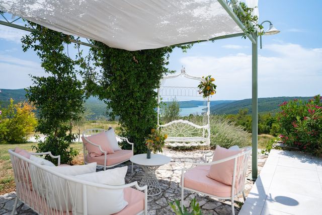 Natkrivena pergola s bijelim vjenčanim paviljonom i pogledom na zaljev